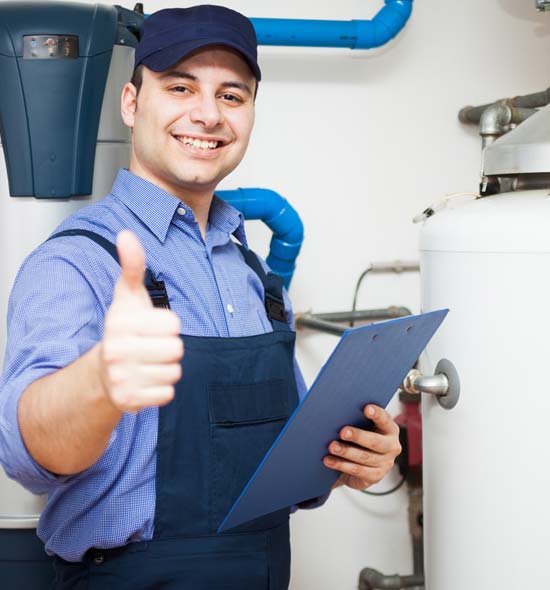 Hausmeister mit Klemmbrett in der Hand vor einer Heizungsanlage