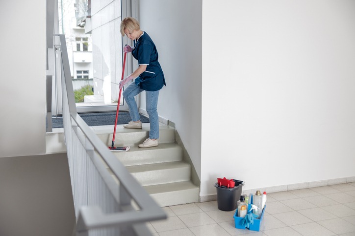 Eine Mitarbeiterin bei der Treppenhausreinigung